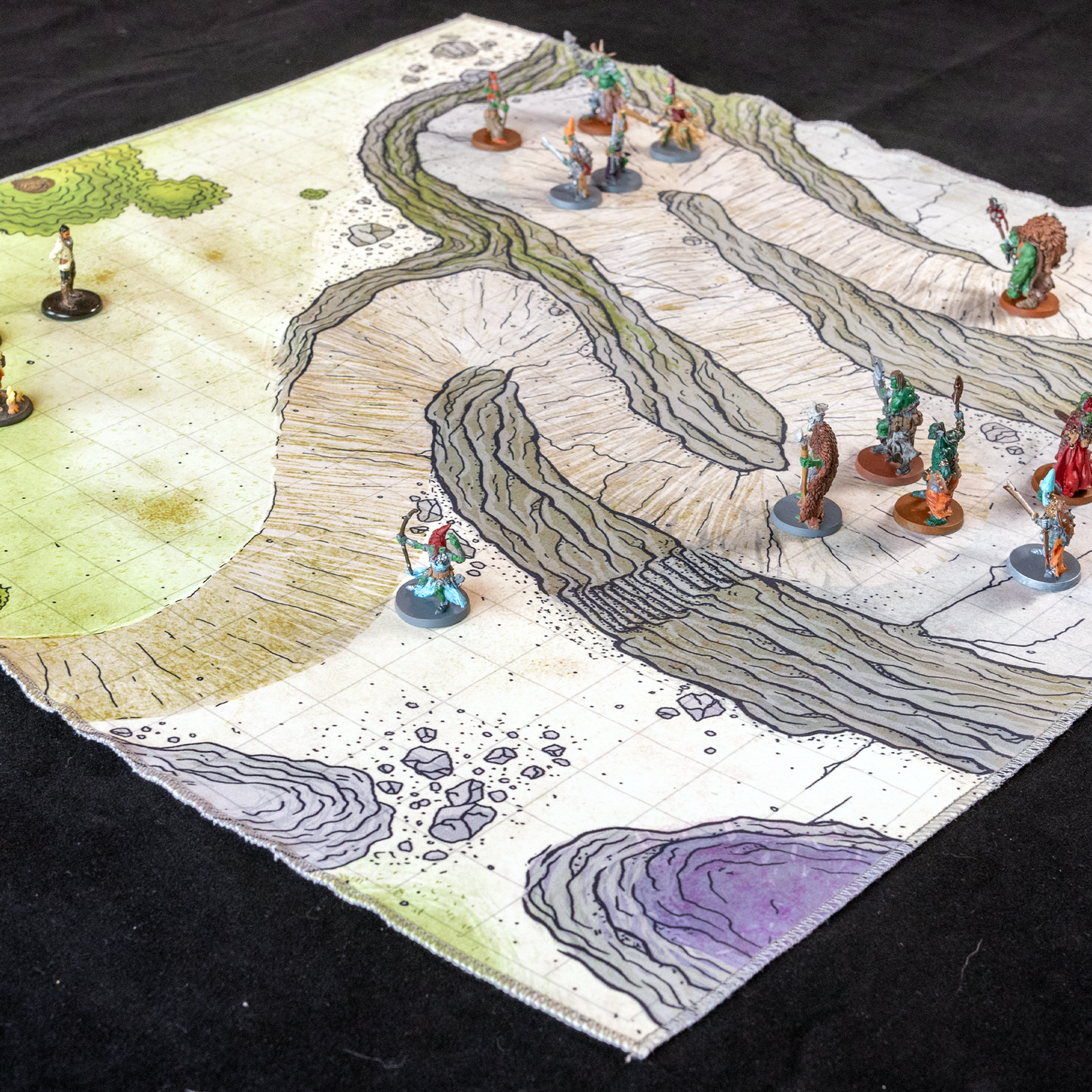 Isometric photo of a cliffside path battle map with adventurers scattered on top of it