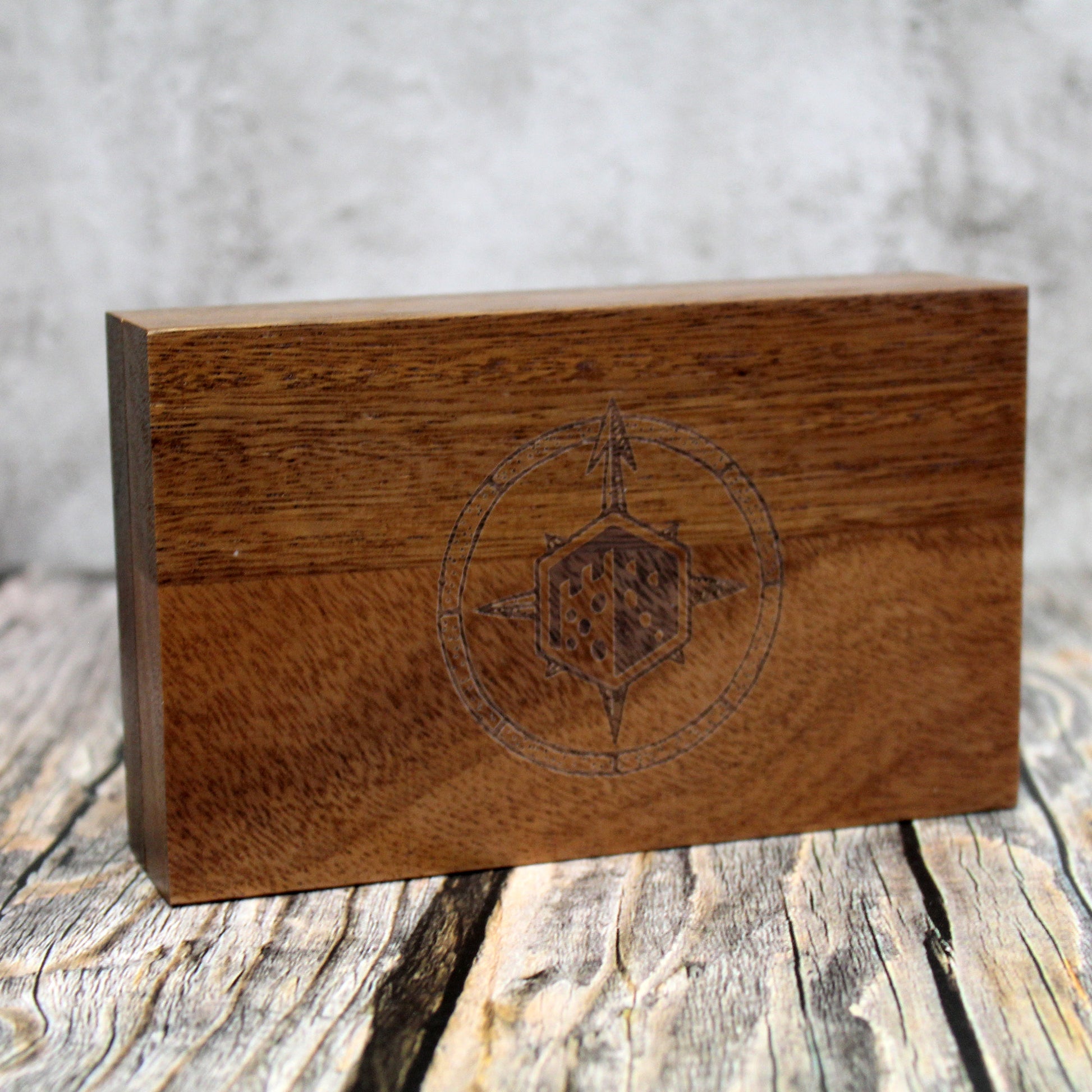 Wooden dice vault for dnd with engraved design on a rustic wooden surface