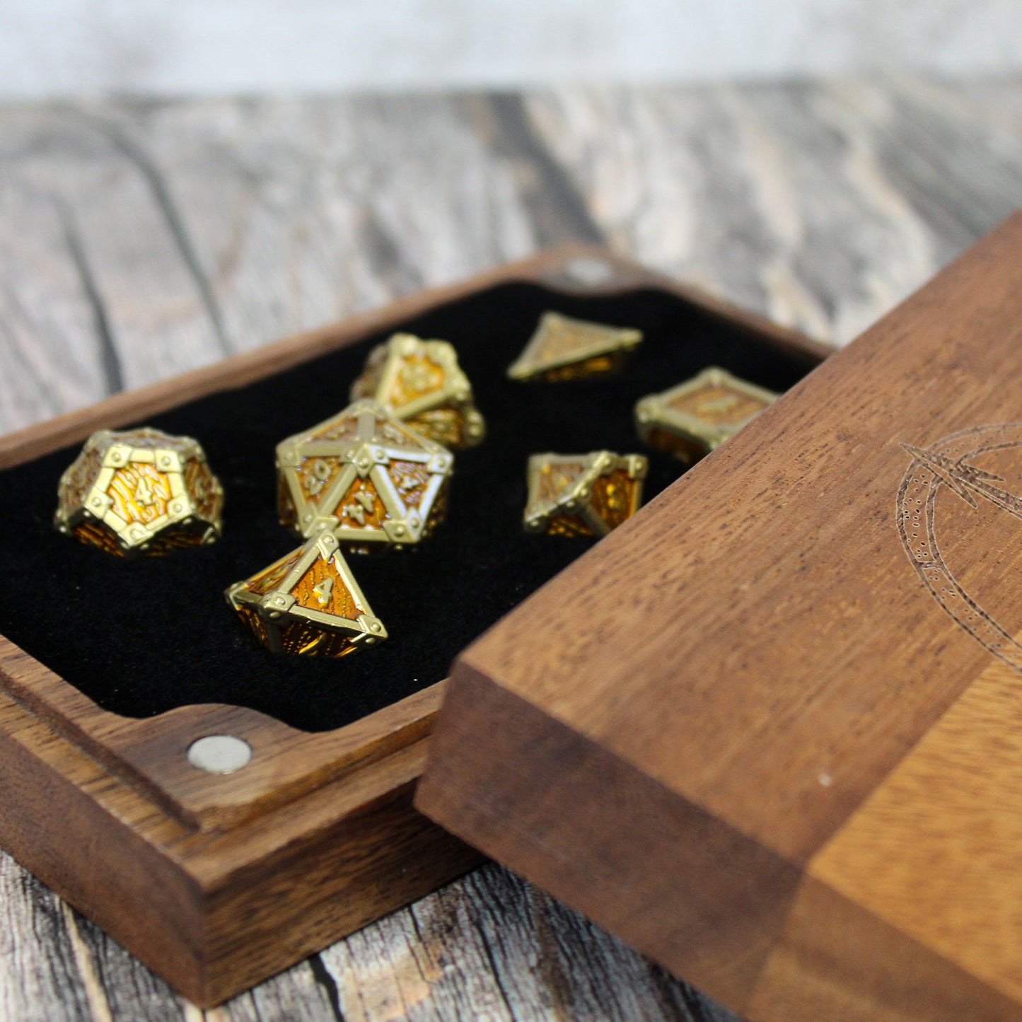 Wooden dice case with gold and brown dice on a wooden surface
