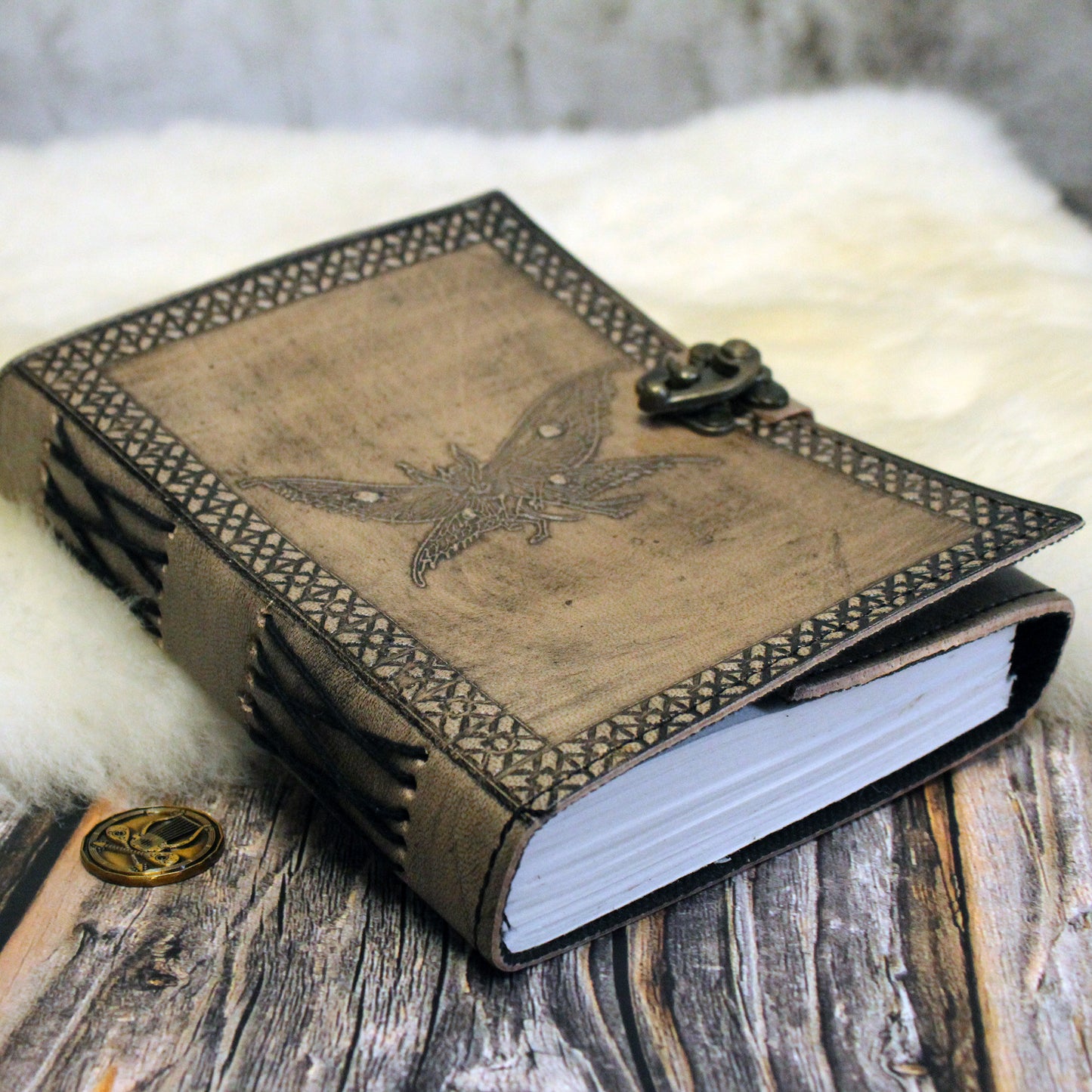 Decorative leather-bound notebook for dnd with mothman design on a wooden surface