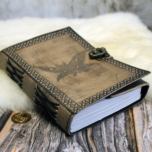 Decorative leather-bound notebook for dnd with mothman design on a wooden surface