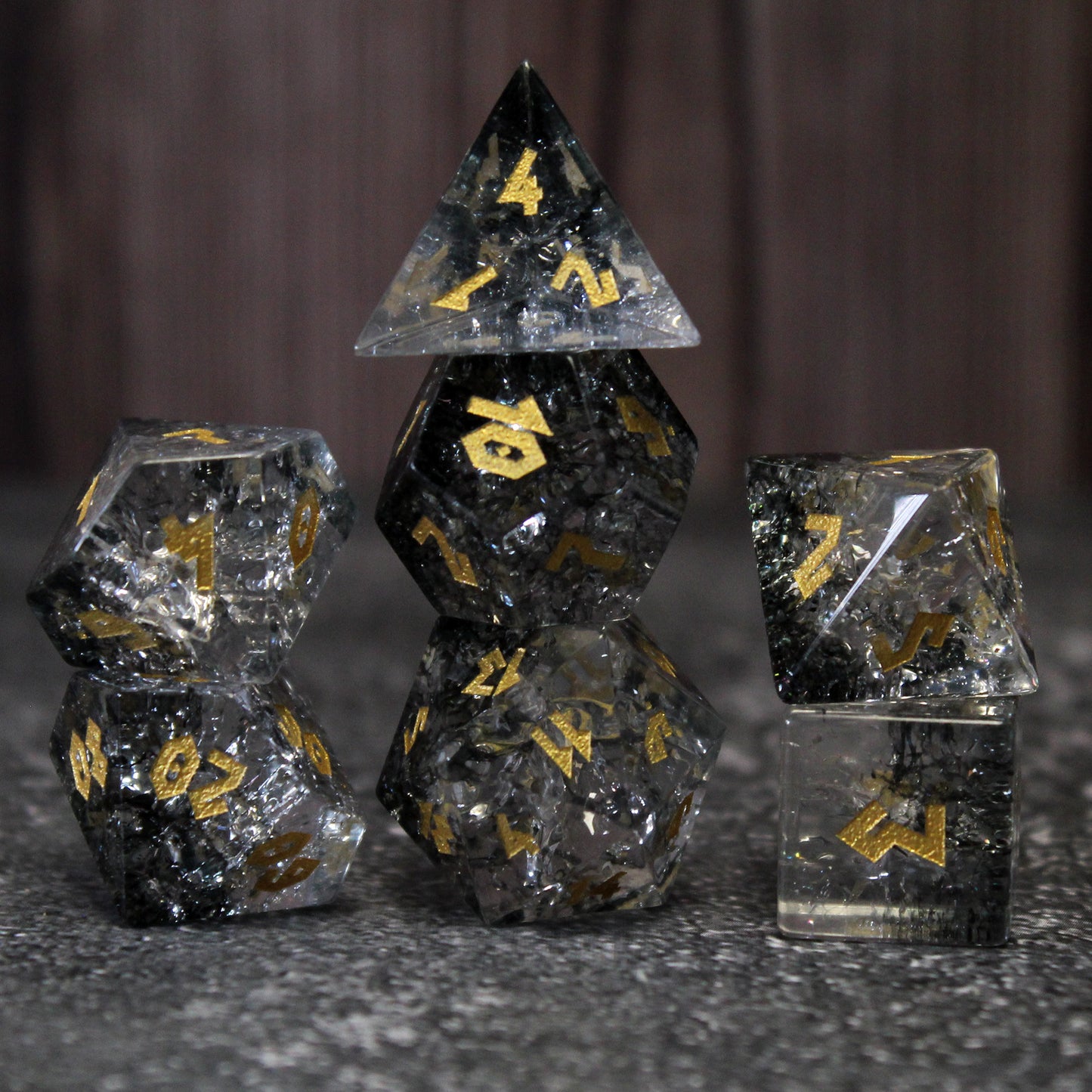 Moon's Shadow dice set on marble with wood background, featuring silver and black shattered glass with gold numbering, perfect for enhancing your DnD gameplay.