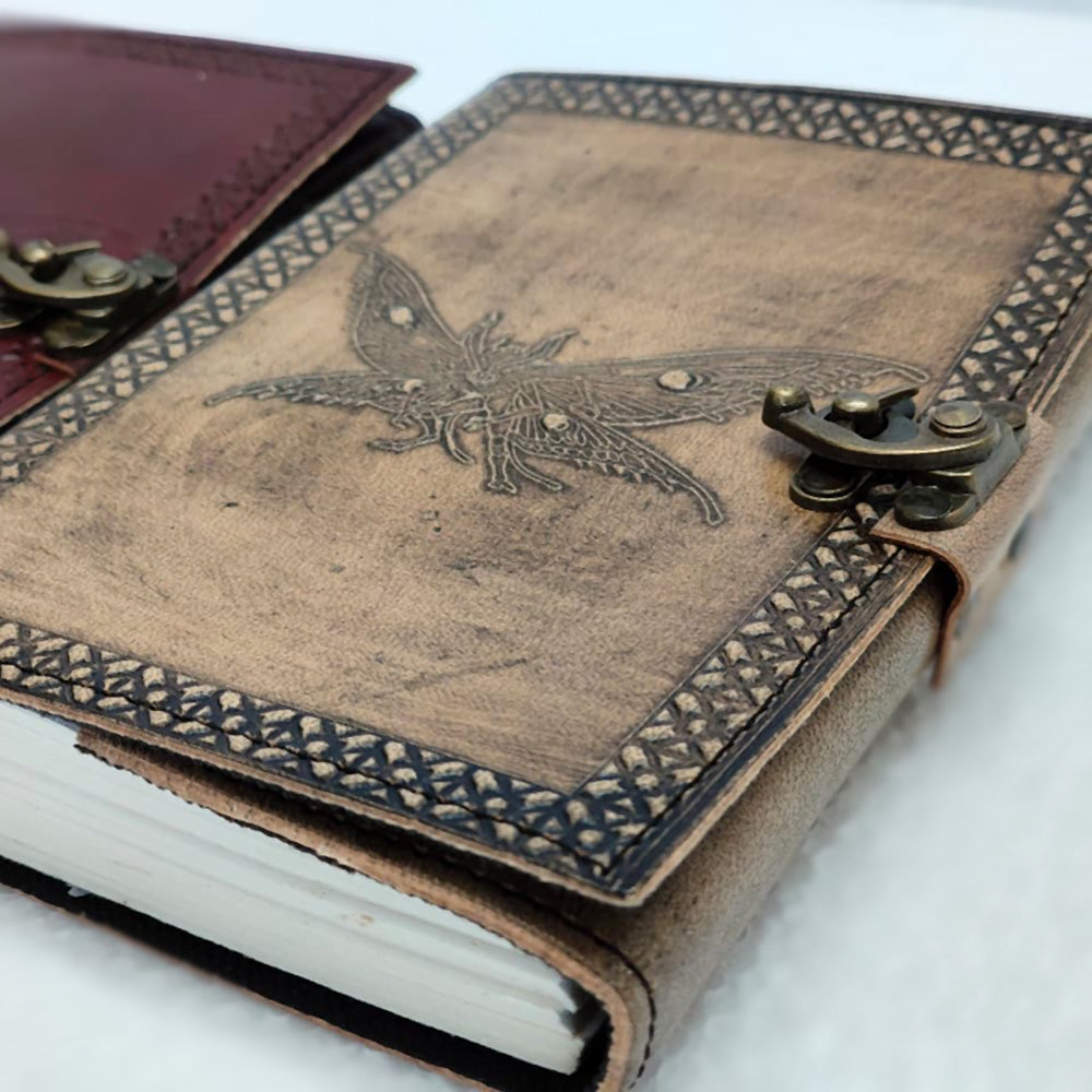 Leather-bound notebook with mothman design and metal clasps on a white background