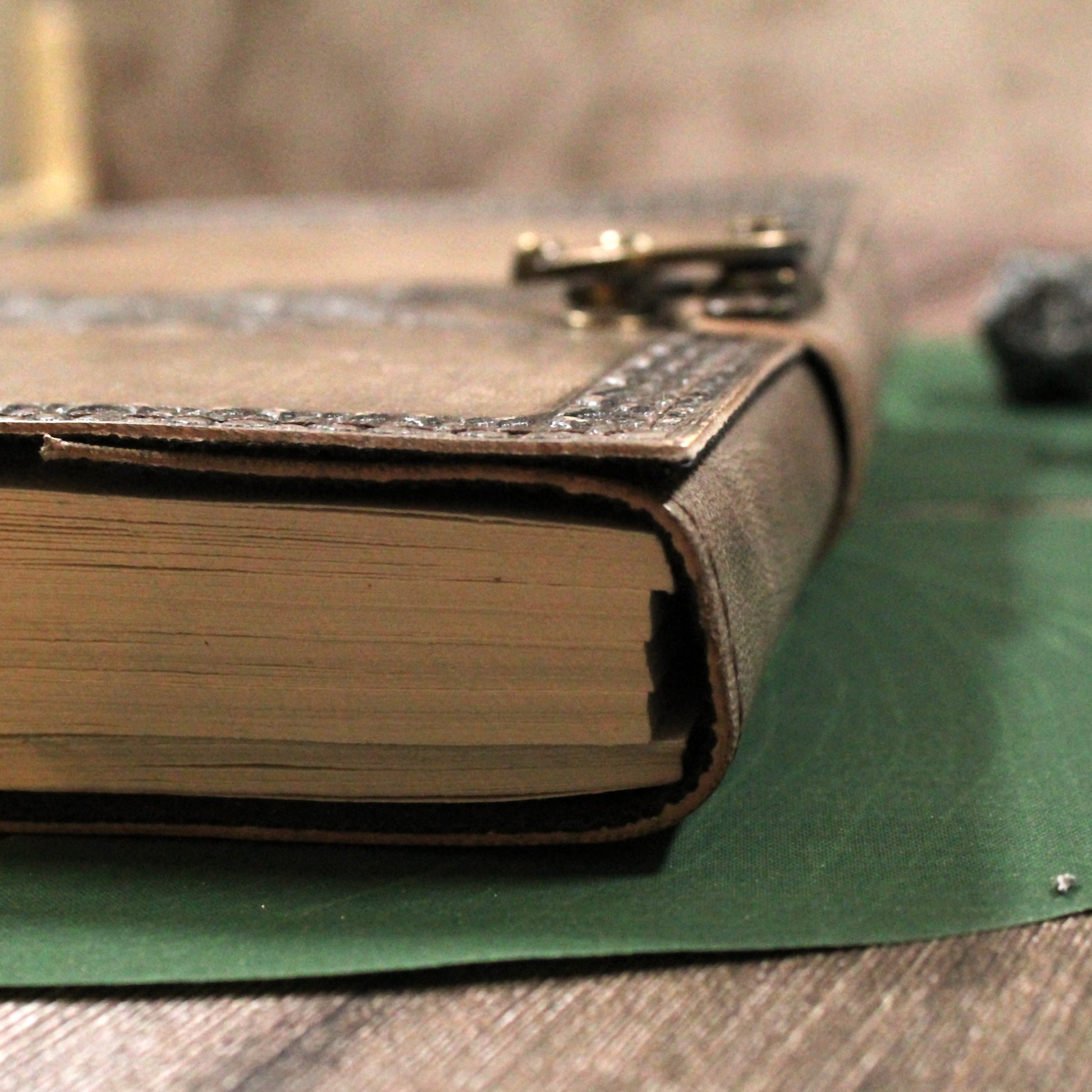 Close-up of a leather-bound book with a lock on a wooden surface