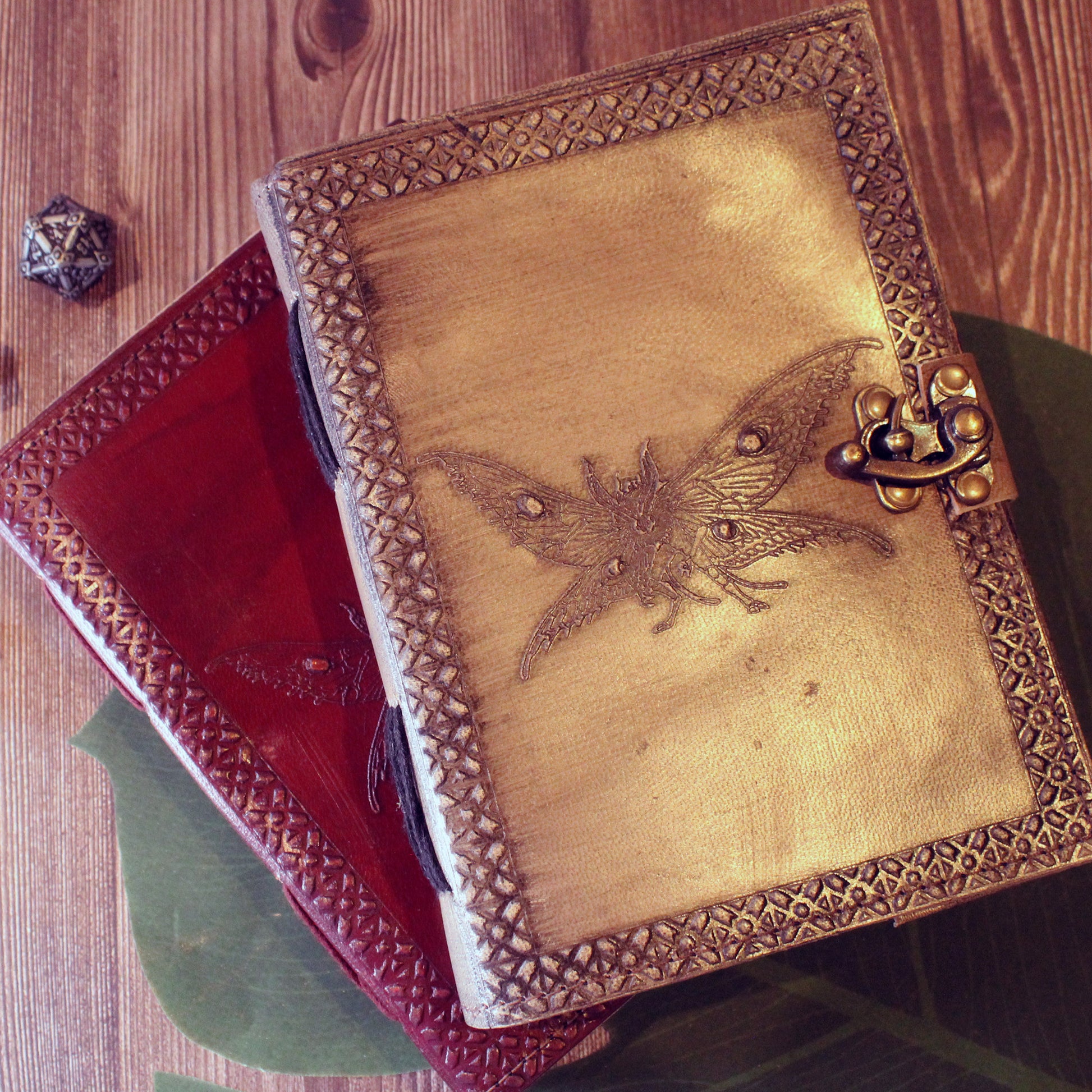 Decorative notebook with moth-man design on a wooden surface