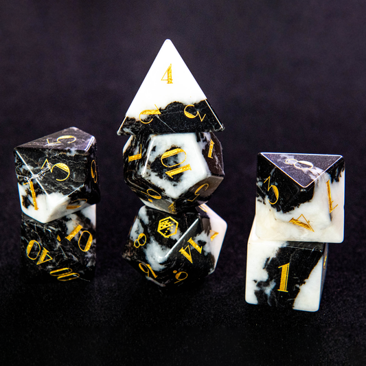 Stacked Milk Cow Jasper Gemstone Dice Set on a black background, showcasing the marbled white and black stone with elegant gold numbering.