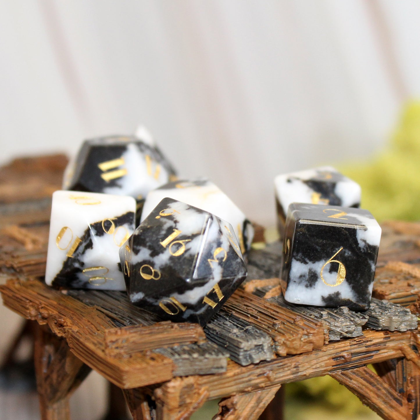 Milk Cow Jasper Gemstone Dice Set on a wooden platform on a game table, emphasizing the natural stone design and luxurious detailing.