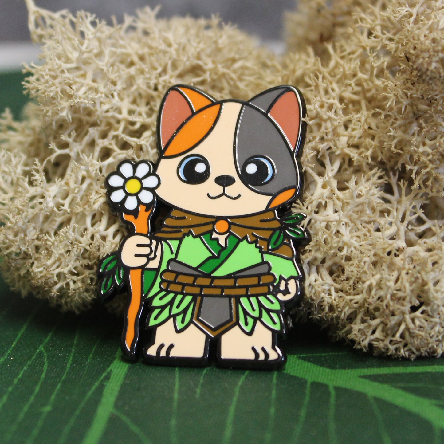 Adventure Cats druid pin displayed on a moss-covered tabletop, evoking a natural, enchanted forest setting suitable for the druid class.