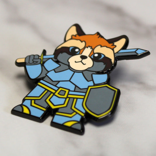 Adventure Cats paladin enamel pin featuring a cat wielding a sword and shield, displayed against a plain white background