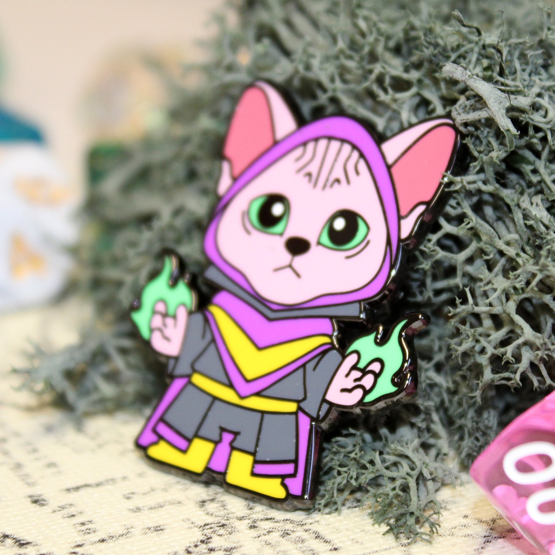 Adventure Cats warlock pin placed on a mossy surface, emphasizing the mystical nature of the Sphinx cat casting magic.