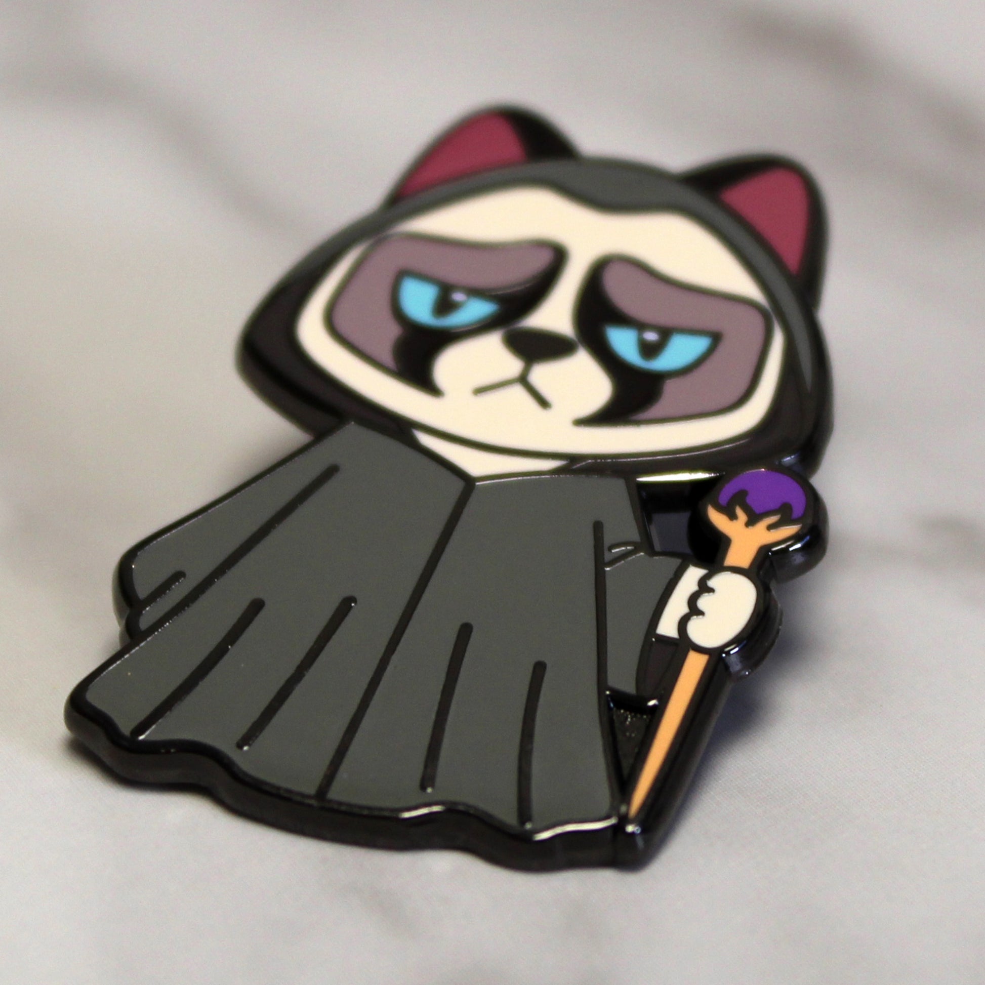 Adventure Cats wizard enamel pin featuring a grumpy cat dressed in a black robe and holding a wizard staff, shown against a plain white background.