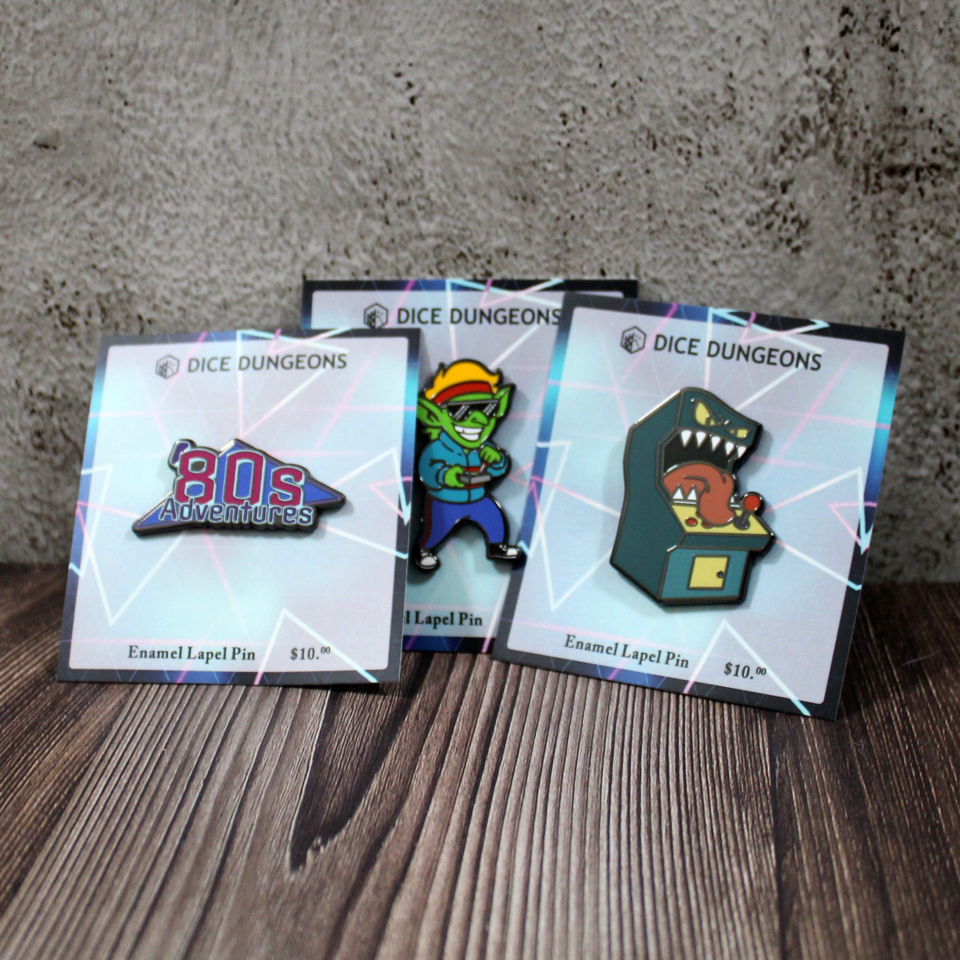 Three enamel pins propped p against a wall