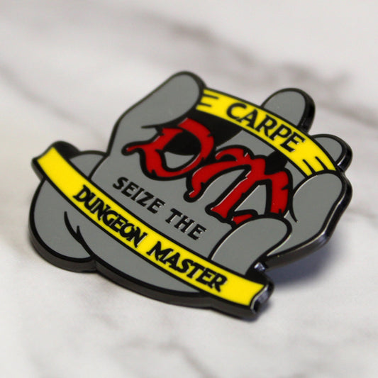 Carpe DM enamel pin featuring the phrase "Carpe DM; Seize the Dungeon Master" with a gripping hand design, displayed against a plain white background.