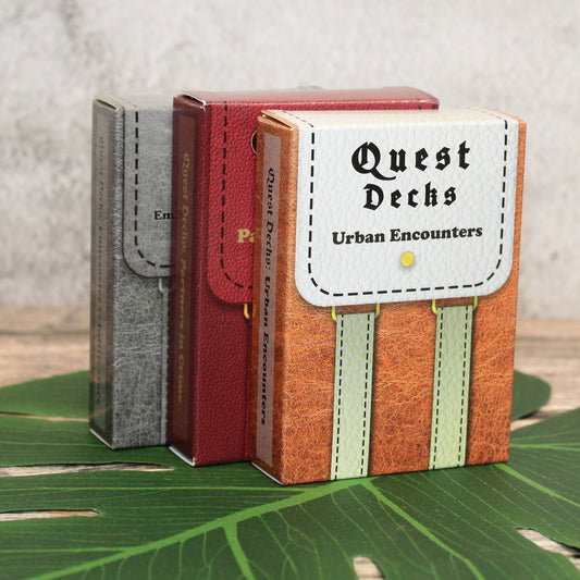 Three Quest Deck boxes displayed on a table, showcasing the bundle that includes 45 city-based quest prompts per deck for RPG campaigns, perfect for adding intrigue, espionage, and criminal activities to urban adventures.