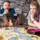 Photo of two people playing a tabletop RPG using a campsite battle map