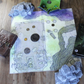 Overhead photo of a ruined temple battle map with tabletop RPG gear scattered around it