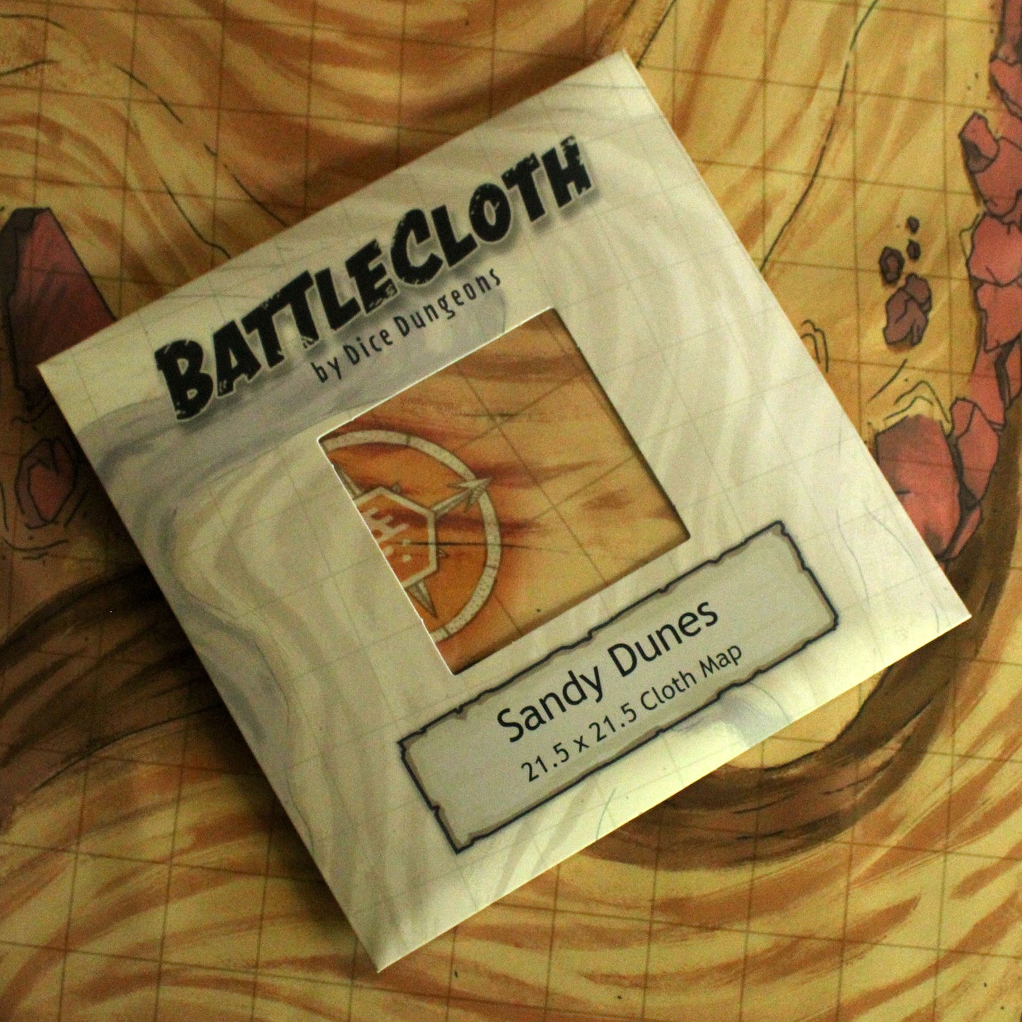 Photo of retail packaging for battle maps that reads "Battlecloth by Dice Dungeons, Sandy Dunes"