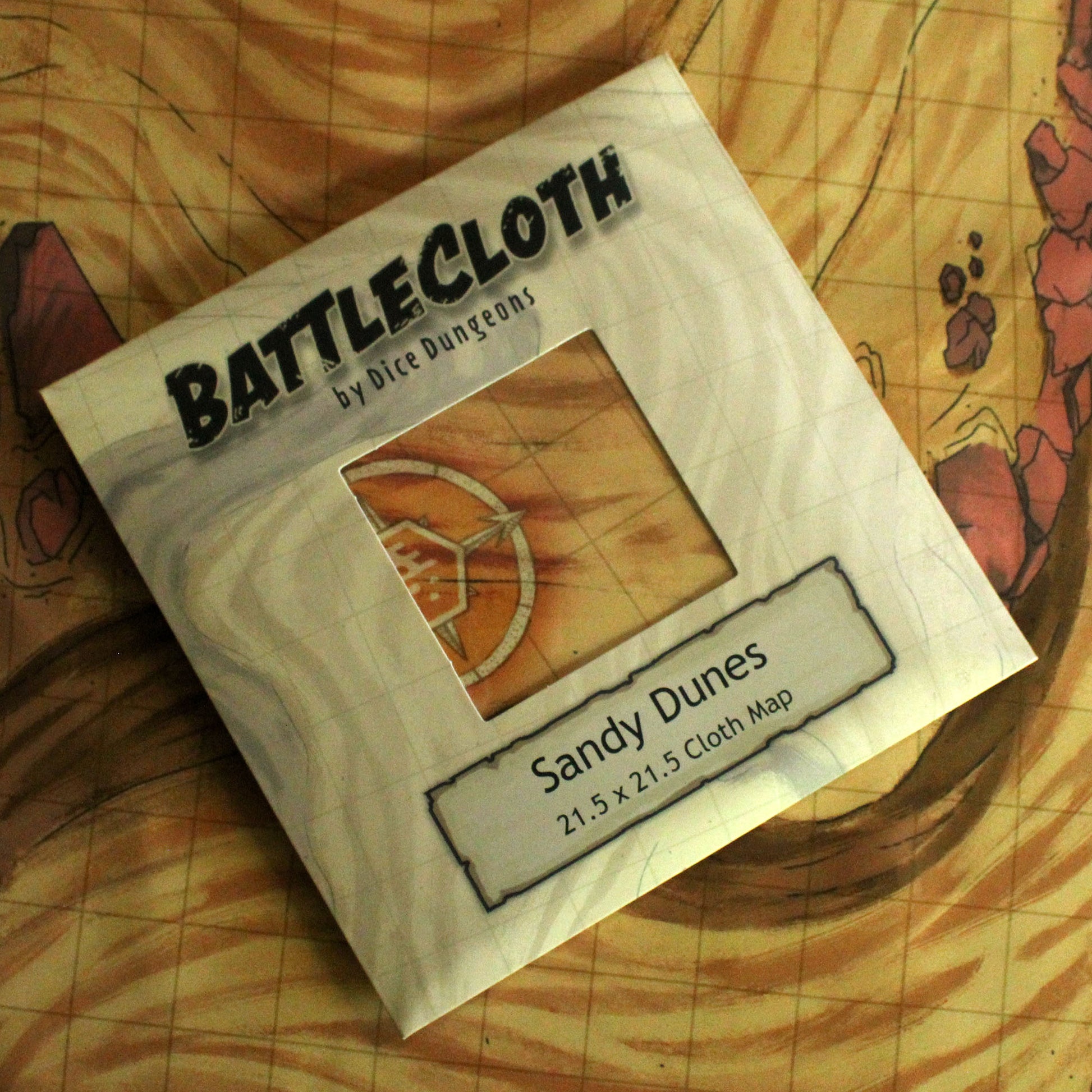 Photo of retail packaging for battle maps that reads "Battlecloth by Dice Dungeons, Sandy Dunes"