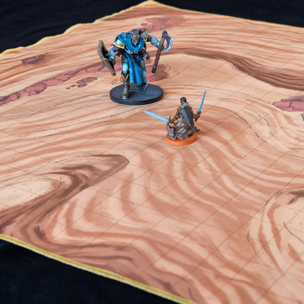 Isometric view of a desert battle map with two miniature figures on it
