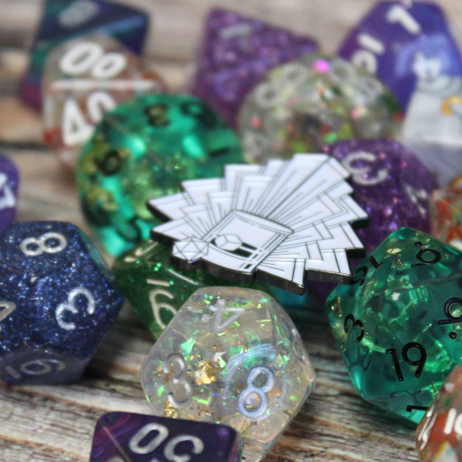 Speakeasy Dice enamel pin displayed with RPG dice sets for scale, highlighting its stylish art deco design. Ideal for TTRPG and D&D fans looking to complement their dice collections with unique gaming gear.