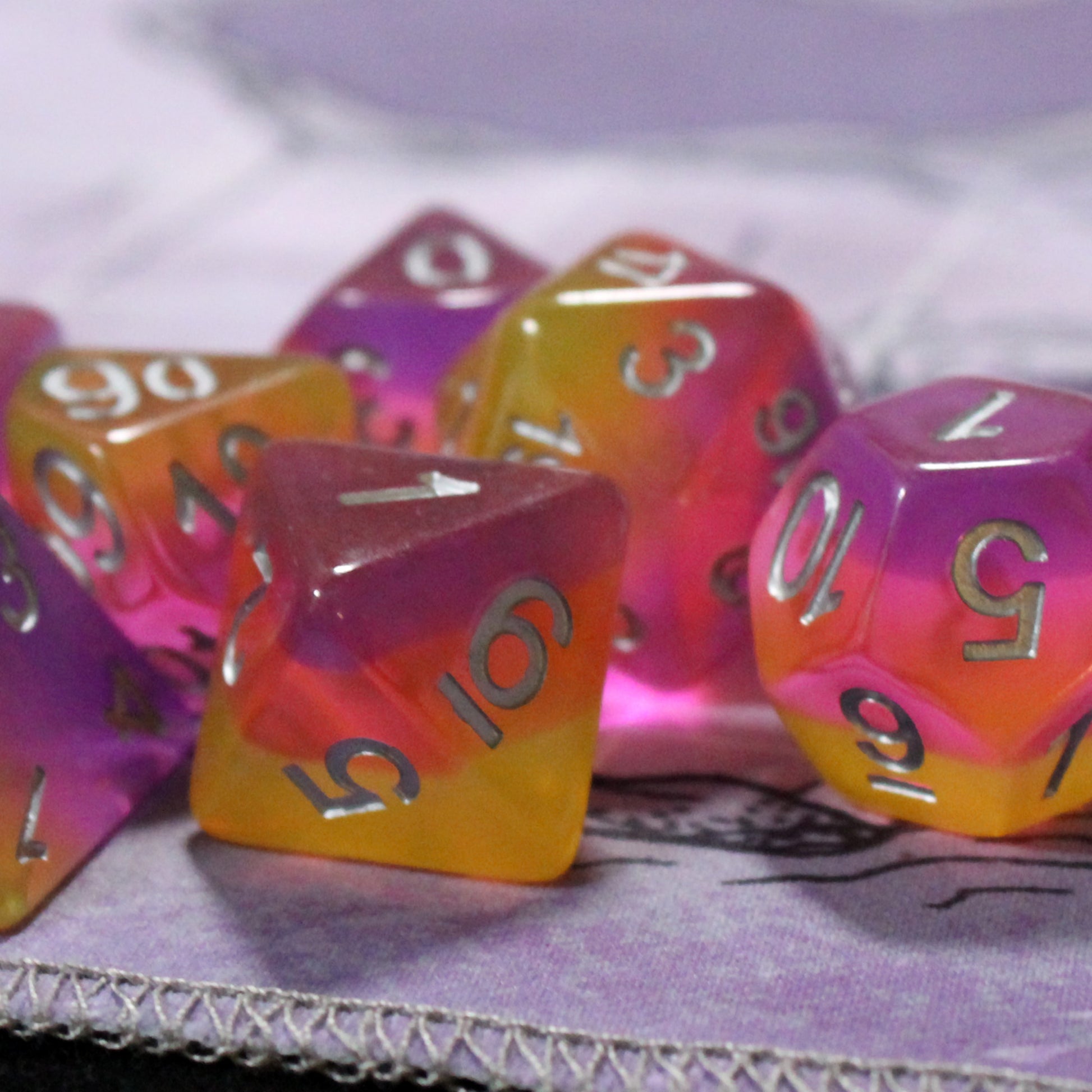 Set of pink and orange polyhedral dice on a textured surface