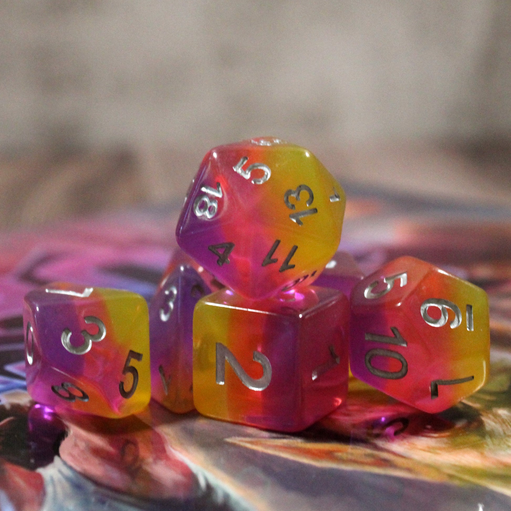 Set of pink and orange polyhedral dice on a colorful surface
