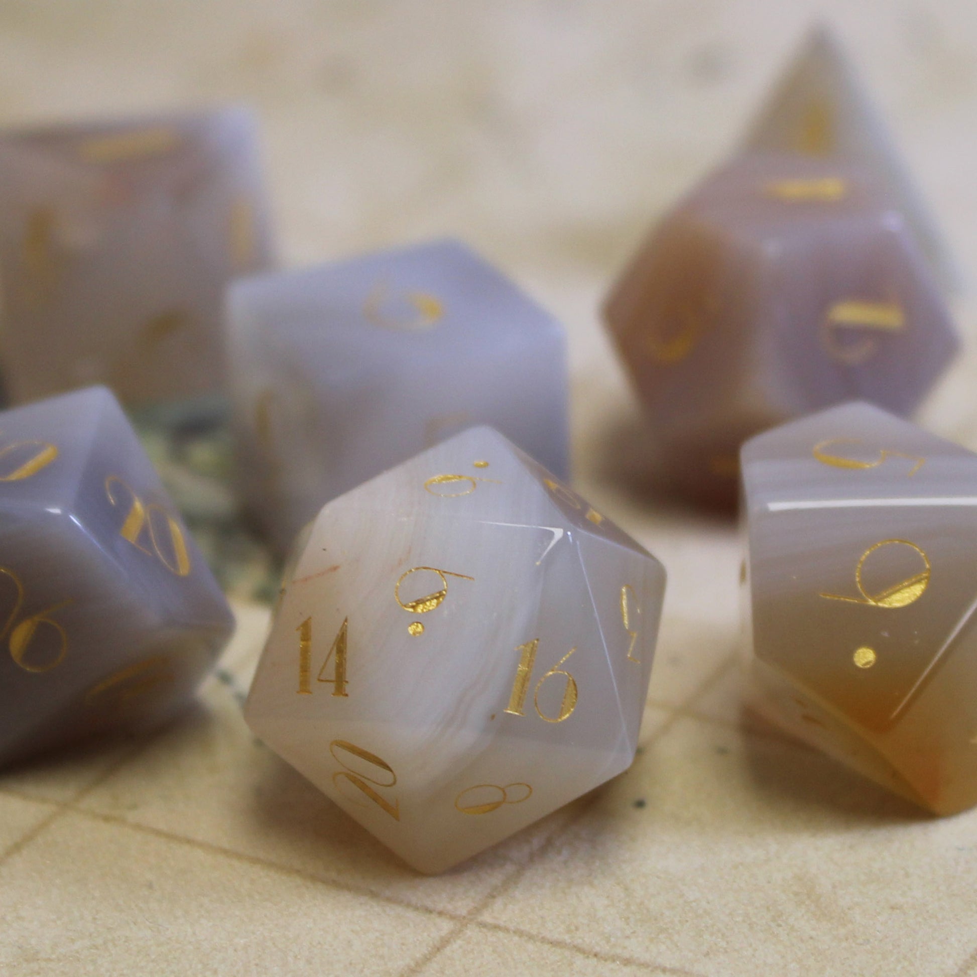 White Stripe Agate Gemstone Dice Set in use on a Dungeons & Dragons battlemap, featuring sophisticated gold numbering and luxurious stone design.