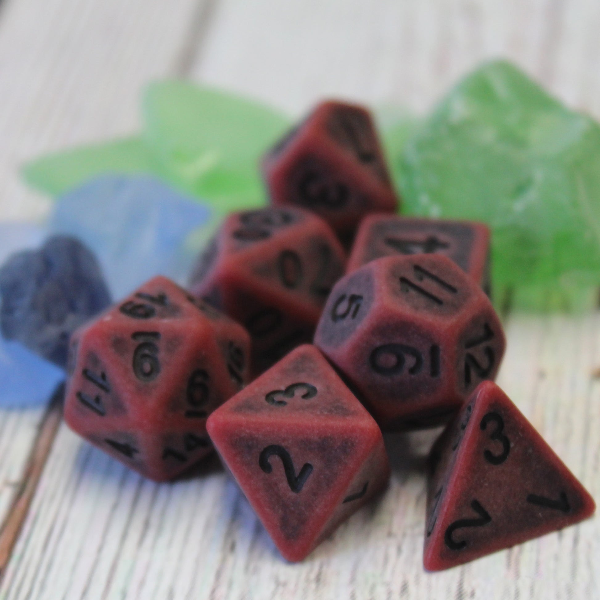 Weathered red dice set arranged on a tabletop, displaying the black numbers and rugged design, suited for bloodthirsty barbarians or veteran characters.