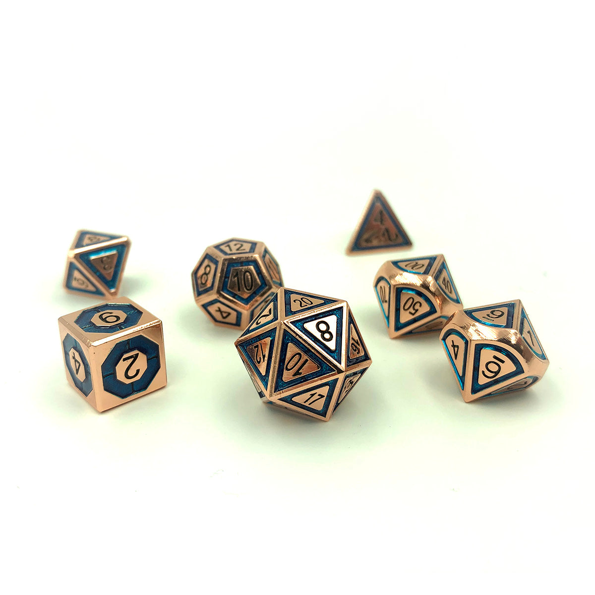 Metal BullsEye Blue Dice Set arranged on a white surface with overhead lighting in a scattered arrangement.  The d20 shows the 20 face and high legibility. The d4 is in the background out of focus and is still readable.