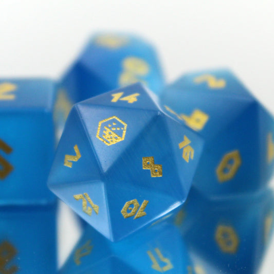 Close-up of the Cat's Eye Blue dice set with the D20 highlighted, featuring a subtle ombre from sea blue to sky blue with gold numbering.