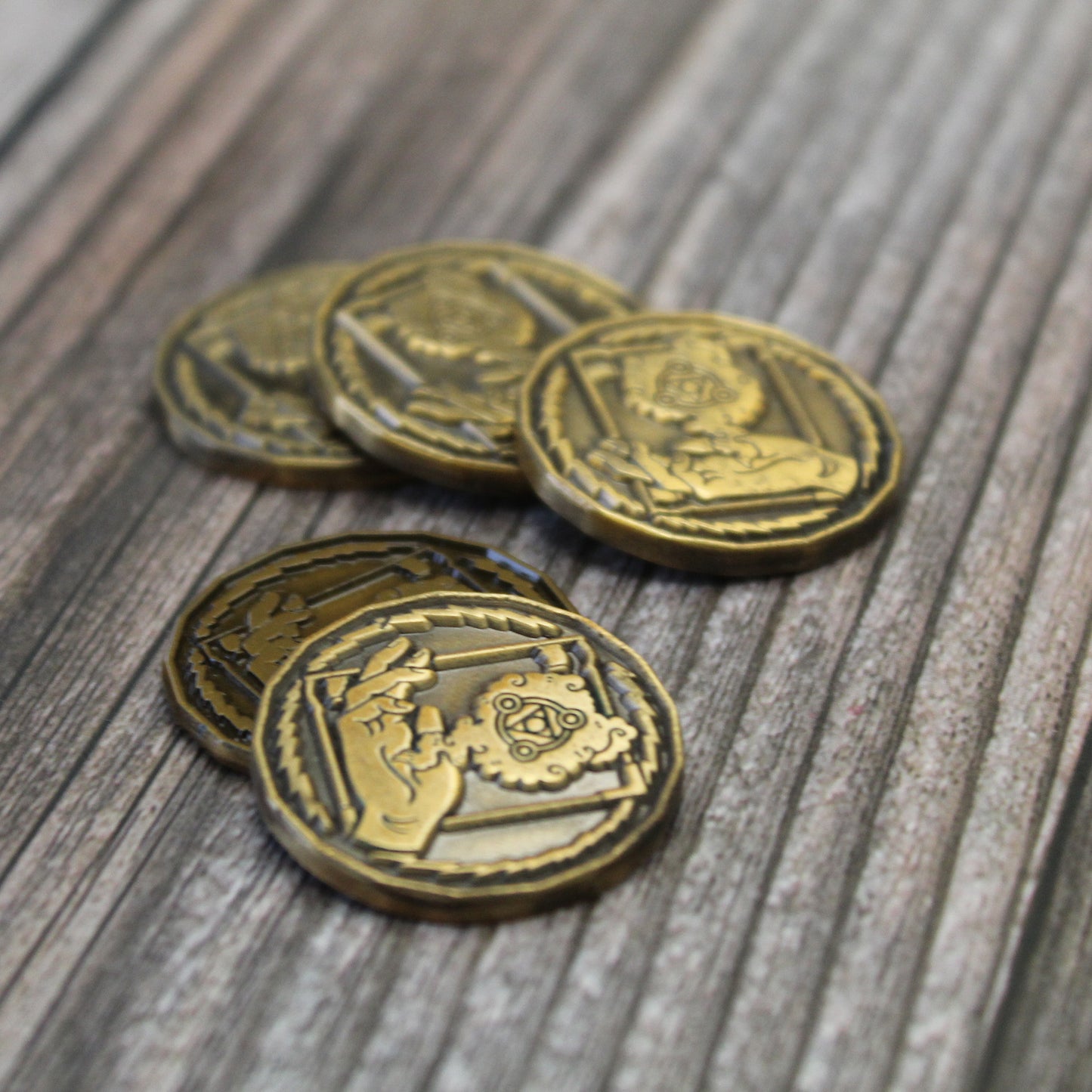 Five golden wizard tokens on wood background