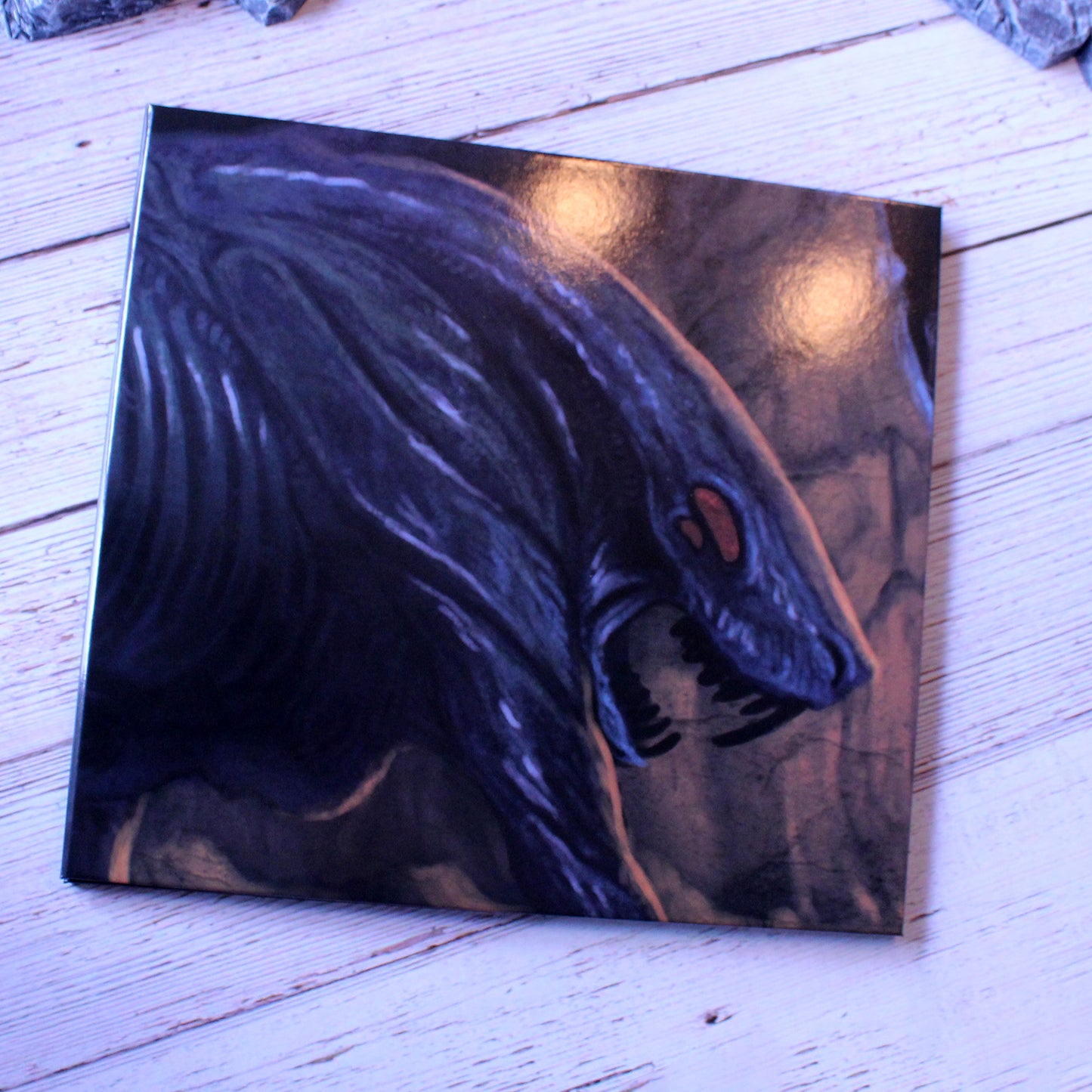 GM Screen folded flat on a wooden table, highlighting durable construction and glossy finish for lasting use in tabletop games.