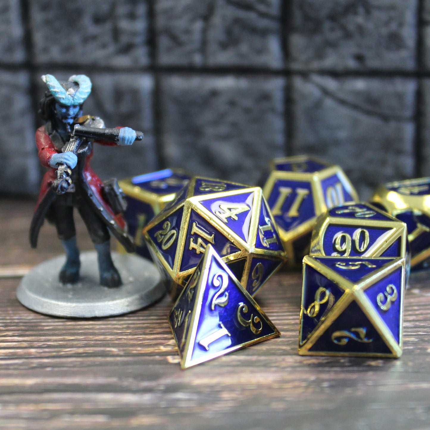 blue and gold metal dice beside mini for scale
