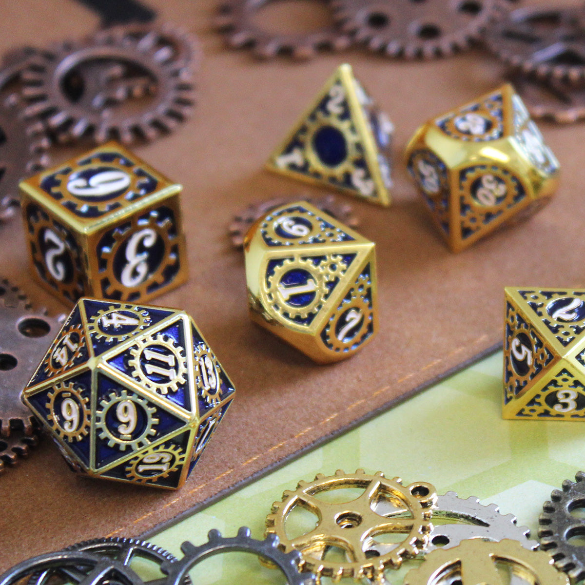 Mechanist d20 and full set in gold and blue on a decorative surface. Each face has white numerals on a blue inset with gears around the numbers.