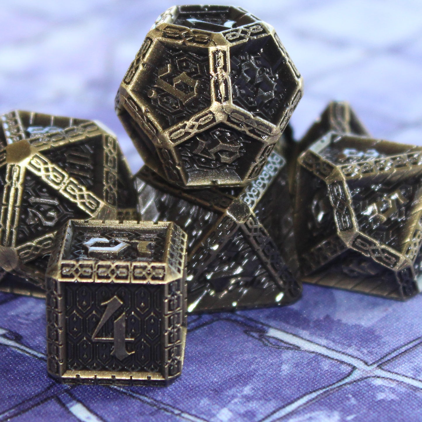 Cavalier Bronze dice set grouped on a cloth playmat with the d12 atop the d8 and the d6 in the foreground.