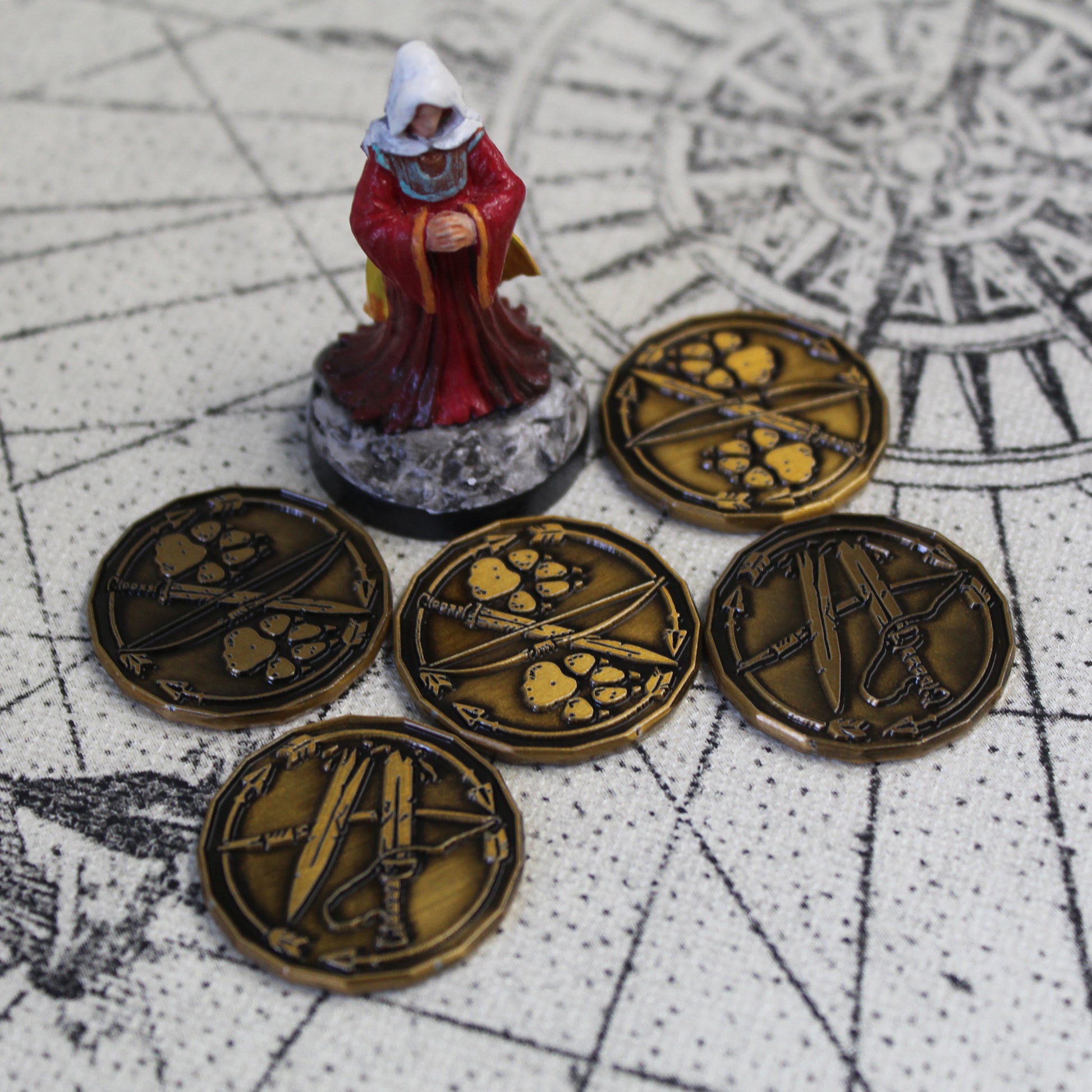 Five golden ranger character tokens sitting on a map next to a miniature figure of an arcane spellcaster