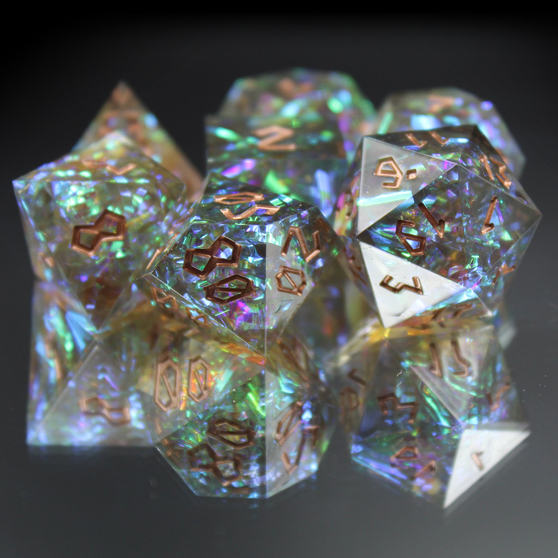 StarGlow Smoke sharp edge resin dice set displayed on a mirror, showcasing gray resin with iridescent flashes of gold, verdigris, and purple.