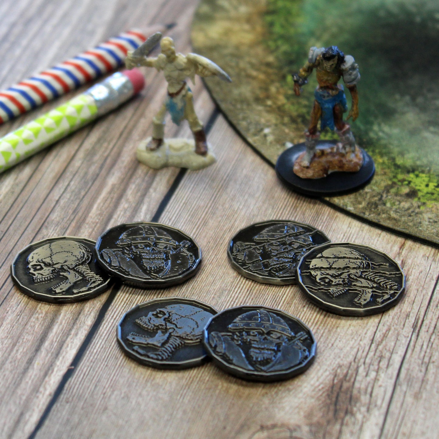 Six Skeleton and Zombie Tokens, with Heads and Tails Sides Showing, Pictured Next to Mini Figures.