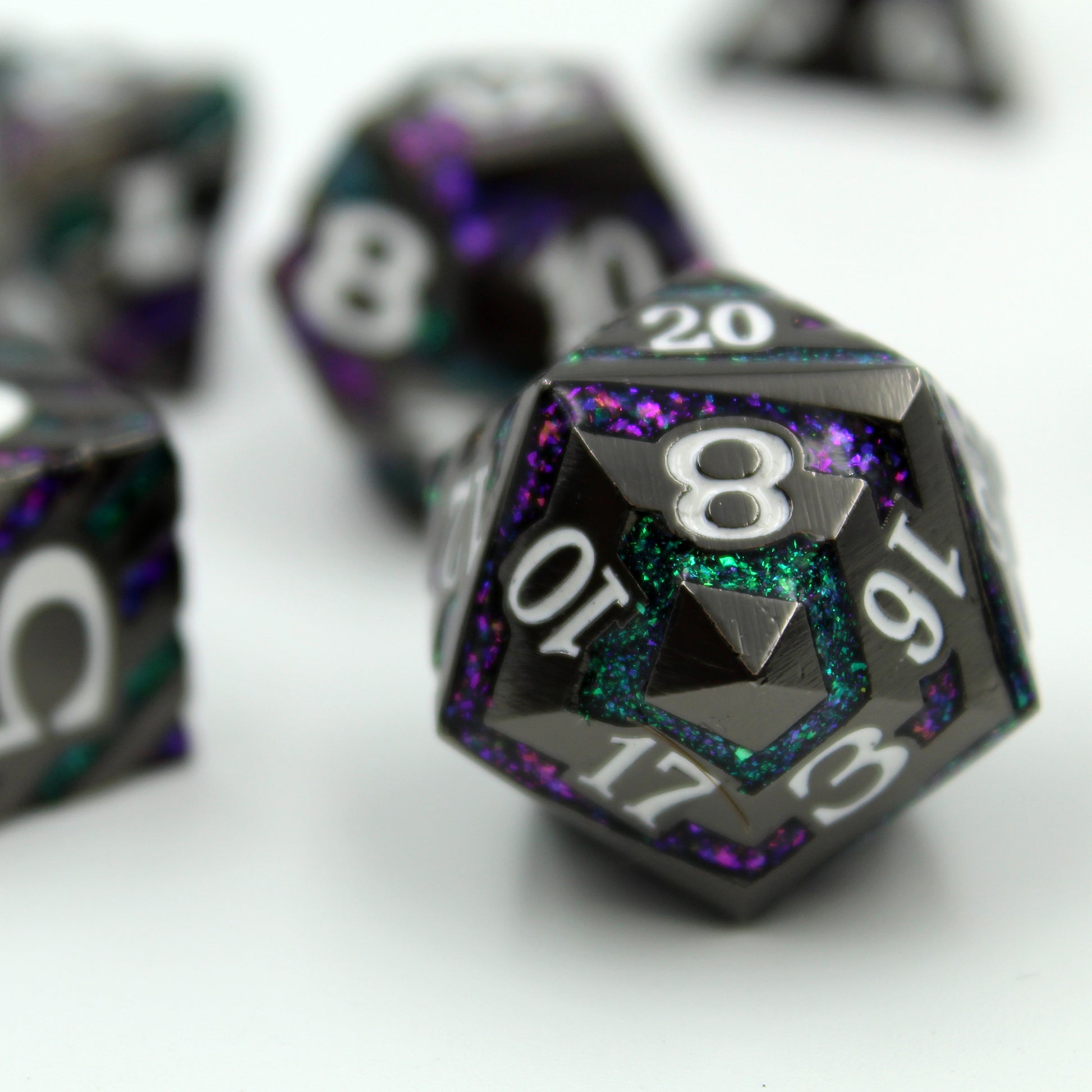 d20 metal dice with stripes of green and purple glitter.