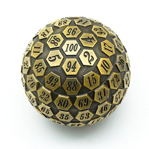 Antique Golden Plated Metal D100 resting on a white surface with the 100 face prominent.